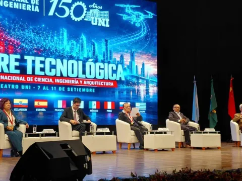 Participantes sentados no palco de evento científico da Universidad Nacional de Ingeniería.
